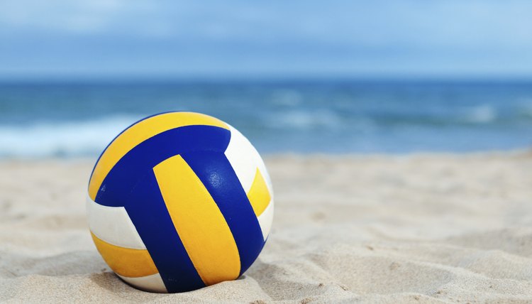 ball is lying on sand near sea