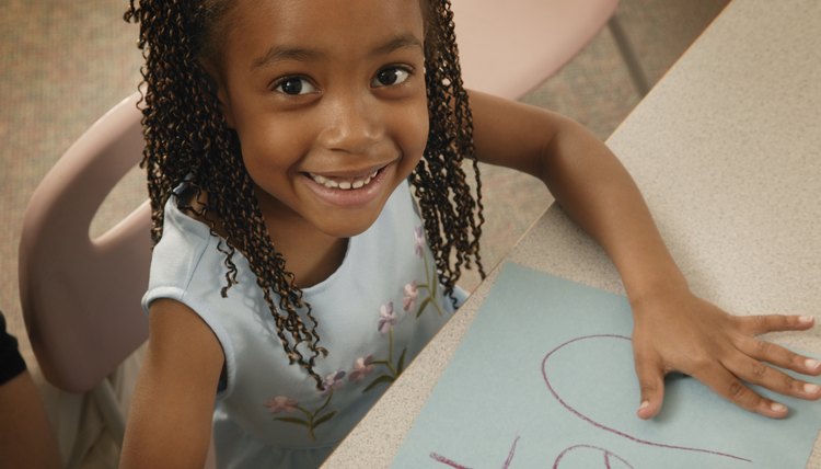 A young girl is drawing a picture.