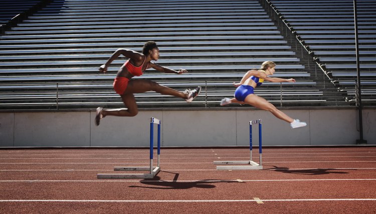 Women jumping over hurdles