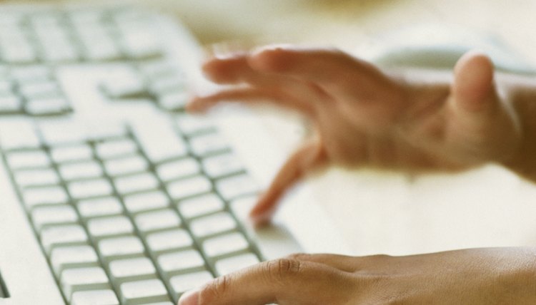A close-up of a child's hands on a computer keyboard.
