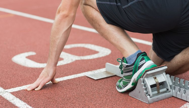 Mid section of a man ready to race on running track