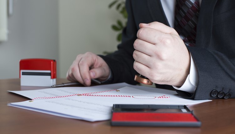 Man's stamping official documents.