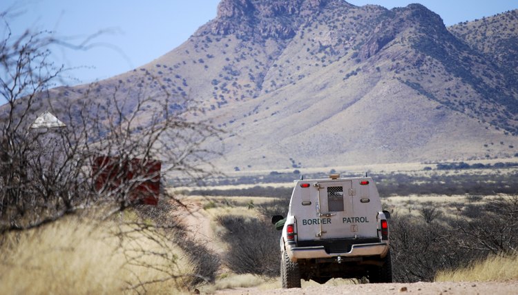Border patrol truck driving on dirt road