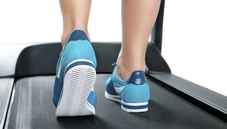 Female legs in turquoise sneakers on a treadmill