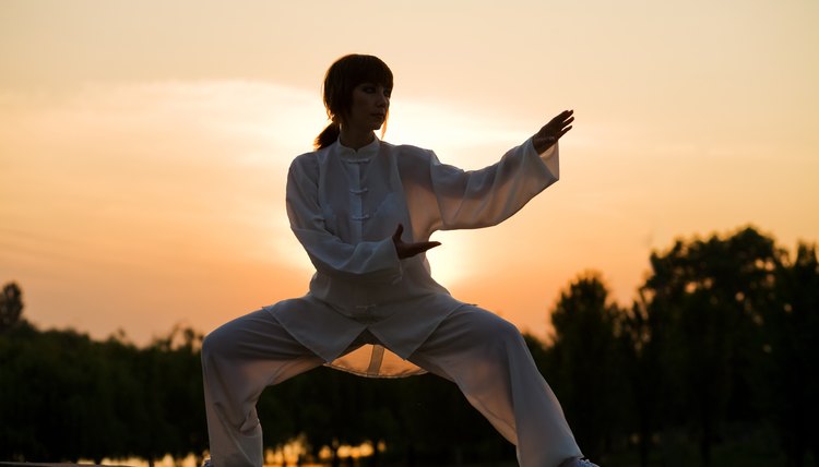 woman in white suit make's taiji chuan exercise - 4