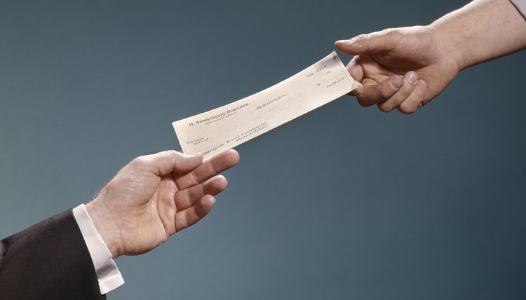 Dos manos intercambiando un cheque certificado.