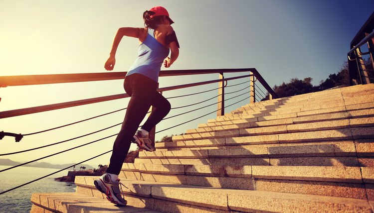 Sportswoman running up on stone stairs