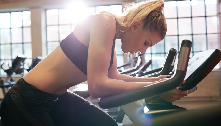 Woman taking break during cycling workout in gym