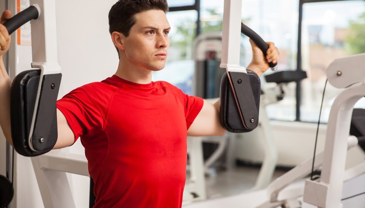 Focused man on a peck deck machine