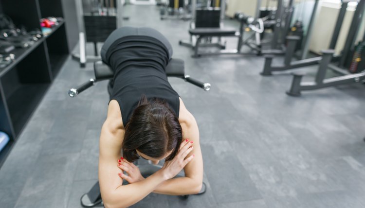 Athletic brunette stretching on the long stairs outdoors, looking