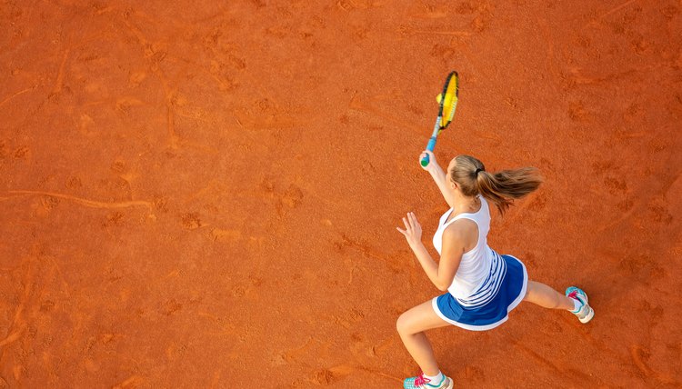 Aerial shot of a female tennis player on a court during match. Young woman playing tennis.High angle view.