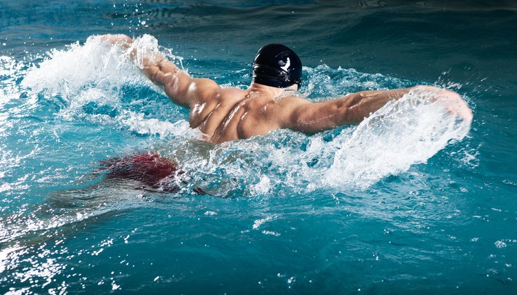 Young healthy man with muscular body swims