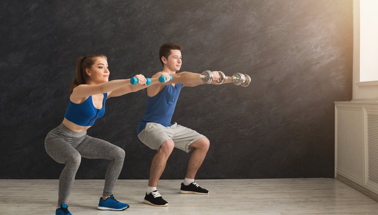 Young couple in sportswear doing squat