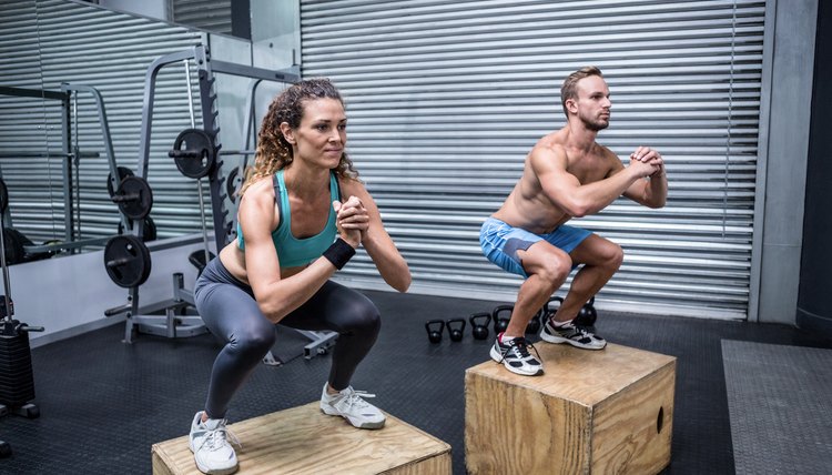 Muscular couple doing jumping squats