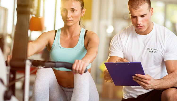 Trainer taking notes on attractive woman working out