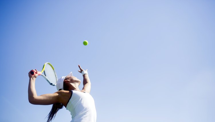 Beautiful female tennis player serving