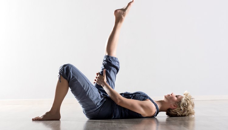 Woman on back stretching hamstring muscles