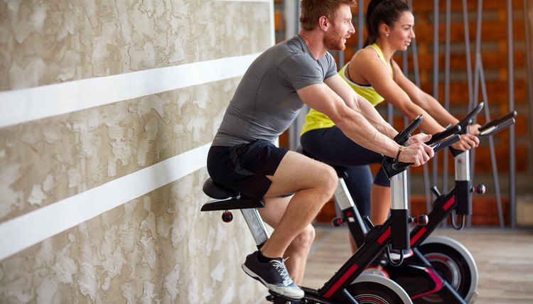 Couple exercises on bike in gym