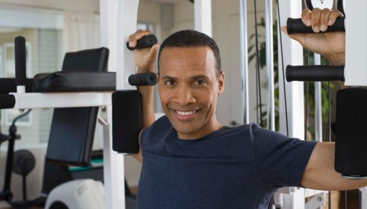 Woman using a chest press machine in a gym Stock Photo - Alamy