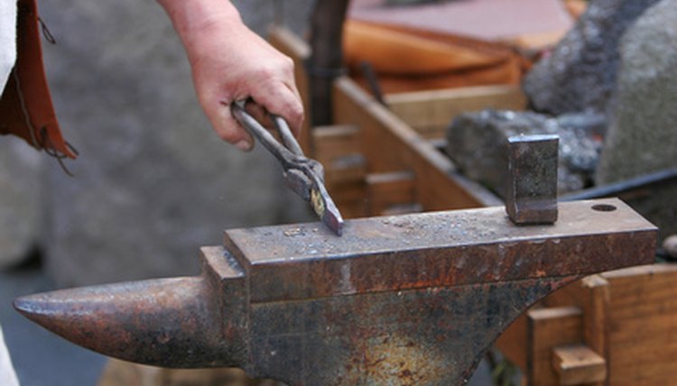 The medieval blacksmith hammered metal on an anvil.