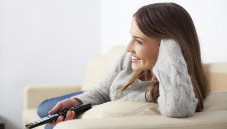 Woman holding remote control watching tv