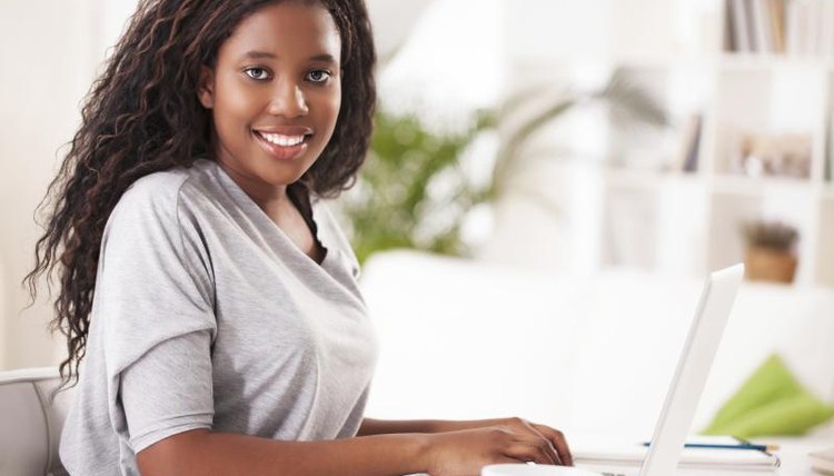 Young female student typing on laptop