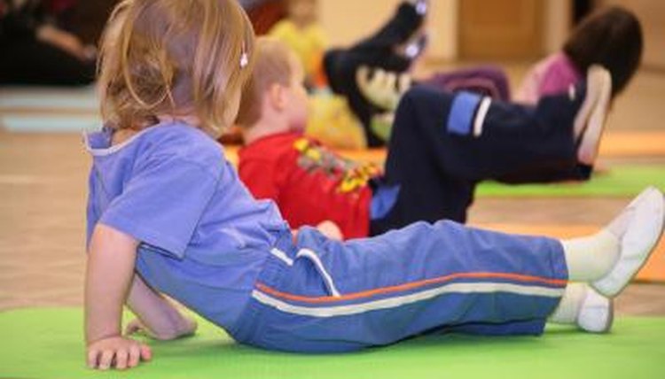 Young child sitting on a mat.