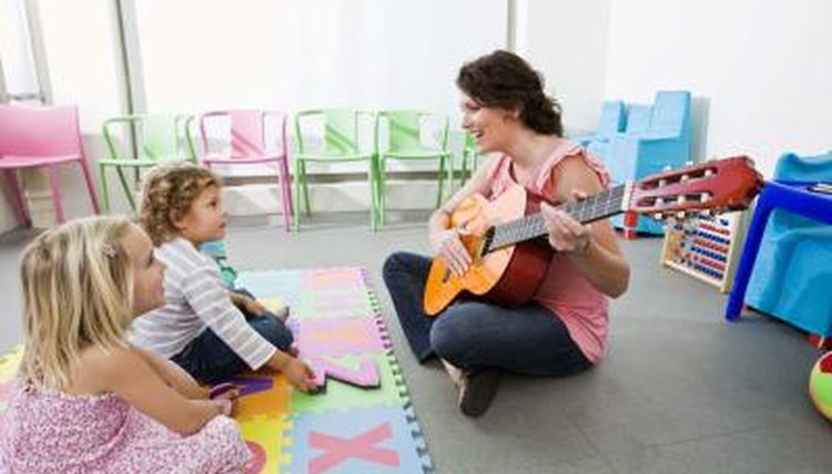 Teacher playing music for young students.