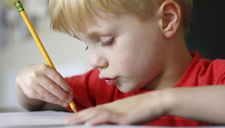 A young boy is writing an essay.
