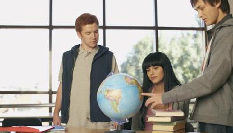 Students looking at globe in class