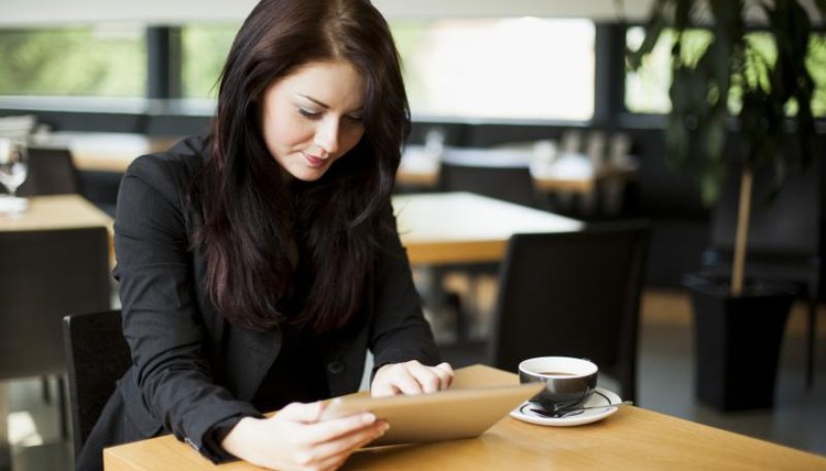 Young female student reading over her essay on a tablet