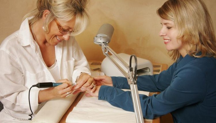 A woman is getting a manicure in a salon.
