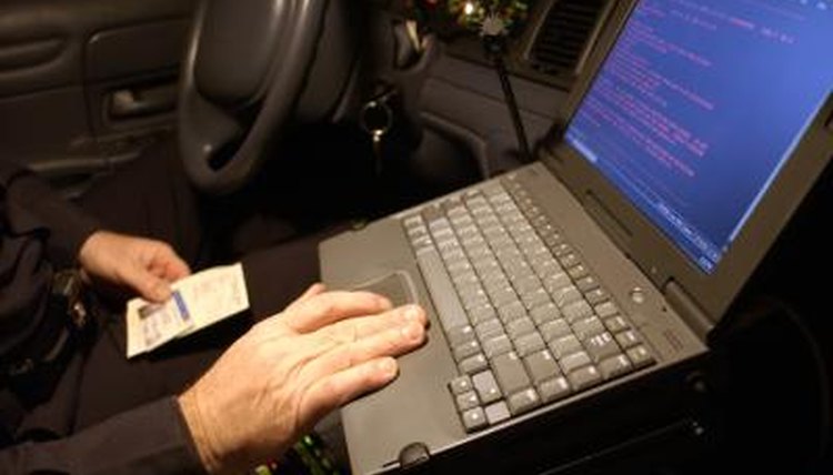 Police officer entering arrest data on computer