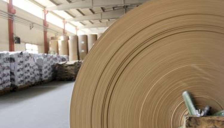 A large spool of paper is produced from recycled material in a factorty