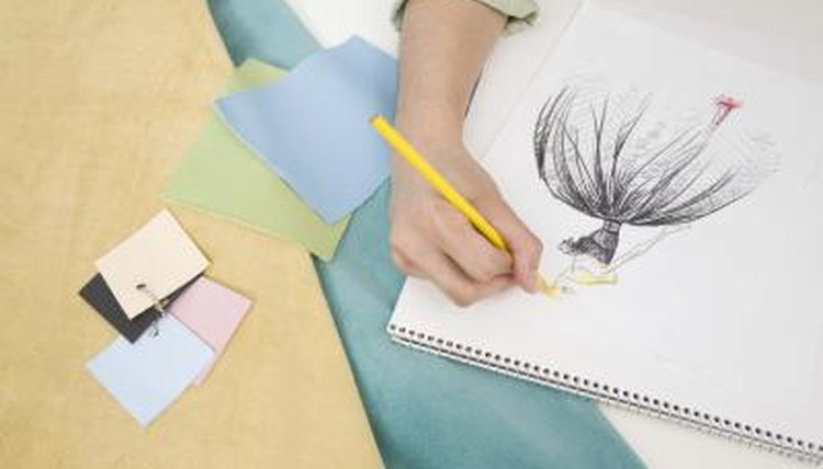 Hands of fashion designer drawing.
