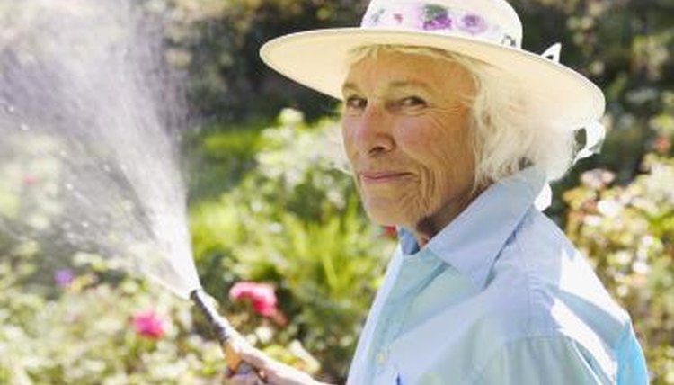 Senior woman watering her garden.