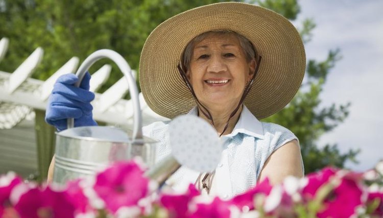 Senior woman watering flowers.