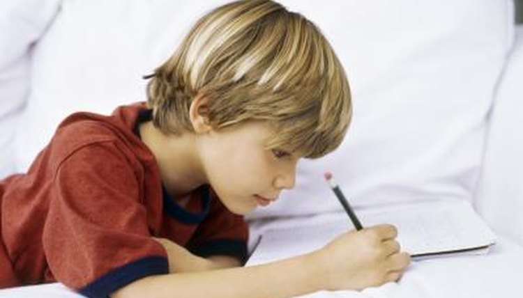 Boy writing on couch