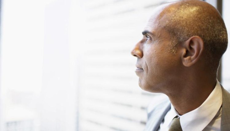 A close-up of a man looking out a window.