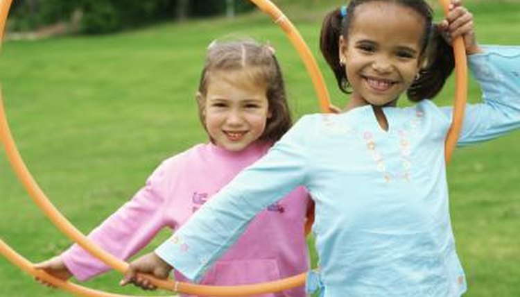 Two young girls holding hula hoops.