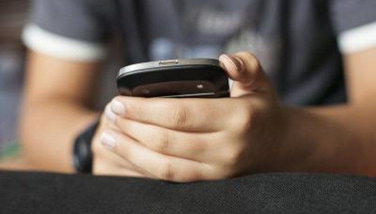 A close-up of a boy holding a smart phone.