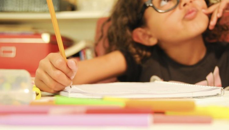 A young girl is writing an essay at home.