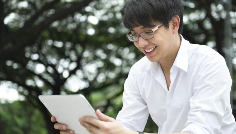An Asian student looks at a tablet computer