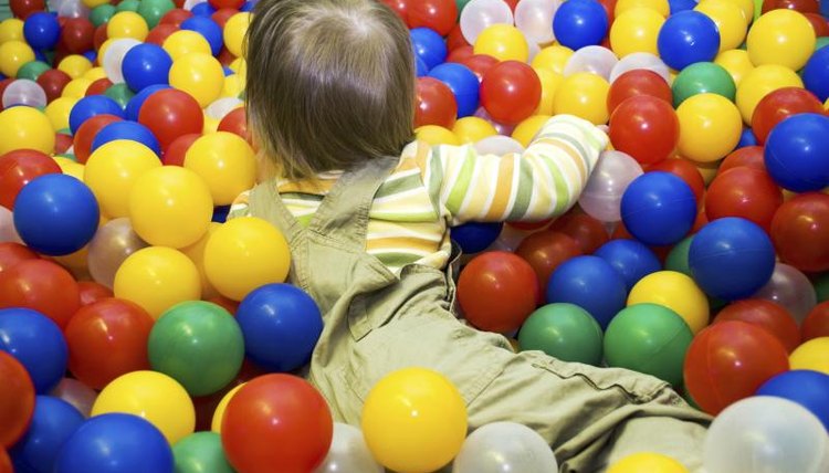 A child playing in a ball pit.