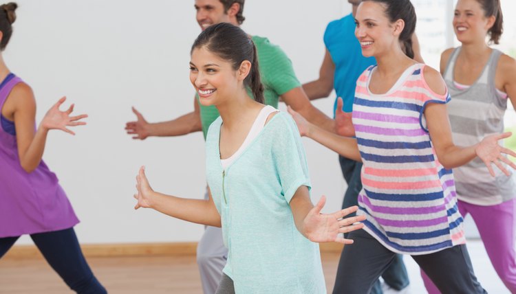 Cheerful fitness class and instructor doing pilates