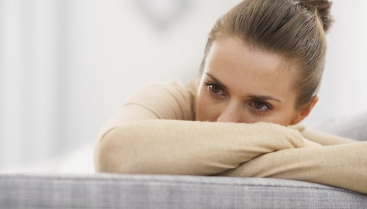 stressed young woman sitting on sofa