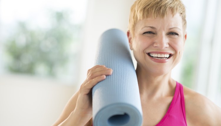 Cheerful Woman Holding Rolled Up Exercise Mat