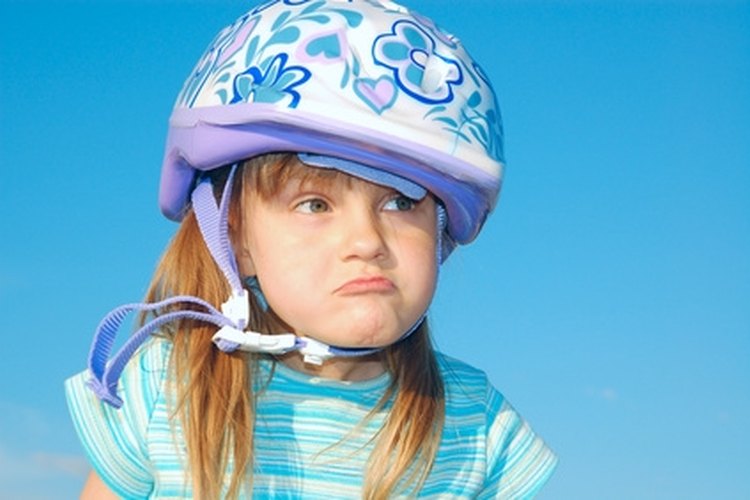 grimacing girl with a helmet image by Cherry-Merry from Fotolia.com Use protective gear when learning to ride on roller shoes.