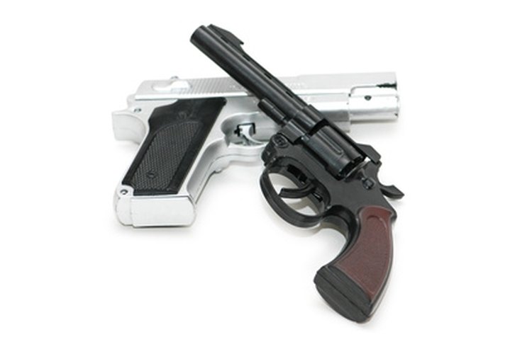 Two guns isolated on the white background image by Elnur from Fotolia.com Dating your handgun can be accomplished by close inspection of details.