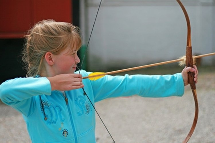 Archer taking aim to hit the bull's eye image by Andris Daugovich from Fotolia.com Back a wood bow with fiberglass.
